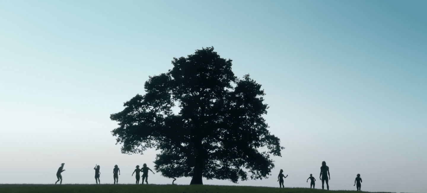 film still from 28 Years Later showing silhouettes of people around a large tree