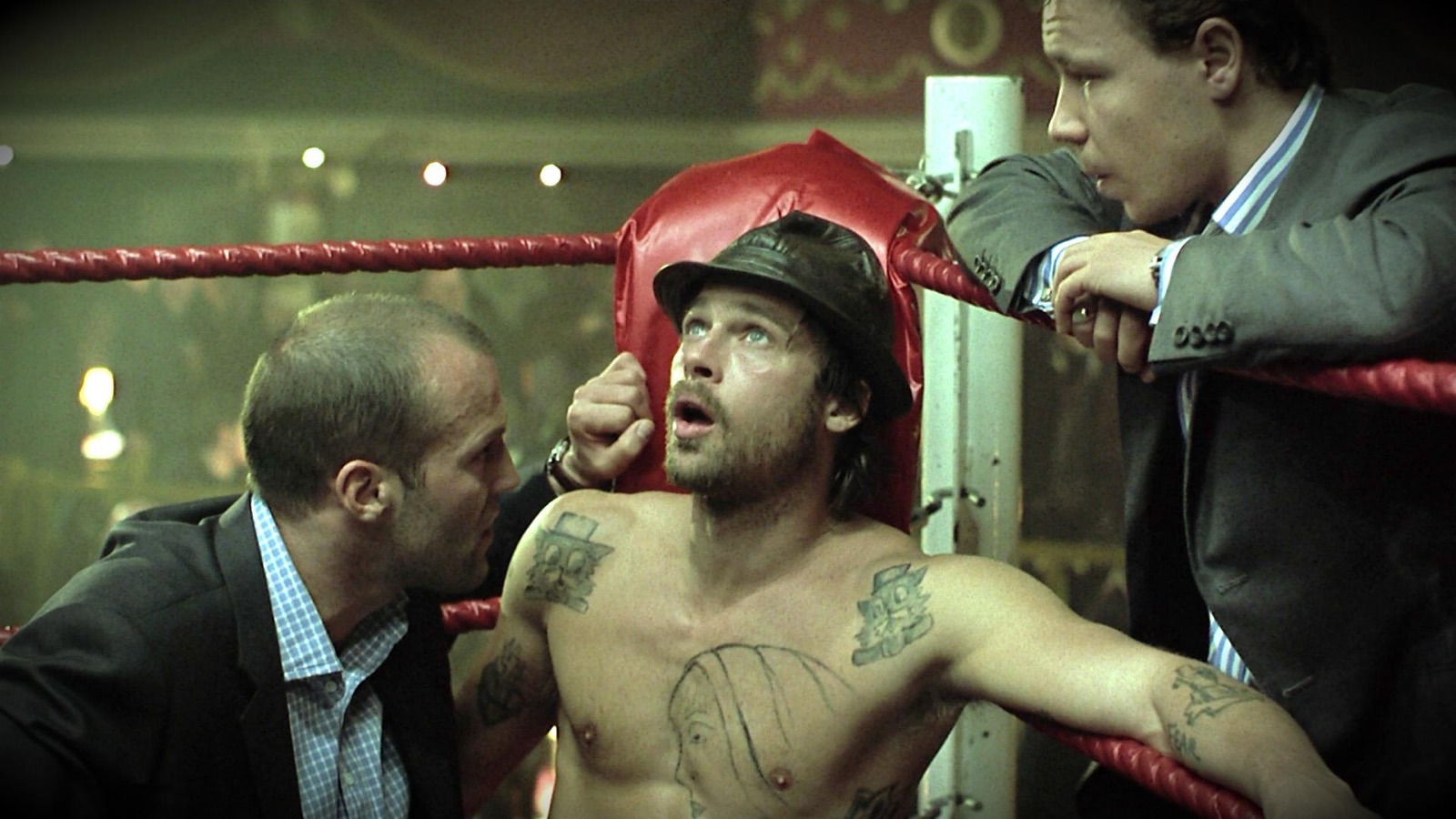 Film still from Snatch (2000) showing Brad Pitt's character sat at the edge of a boxing ring