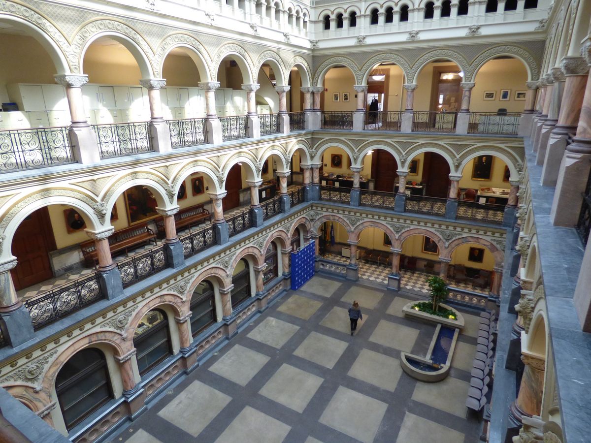 Ornate multi-level arcaded atrium with Romanesque arches and marble columns in upstate New York