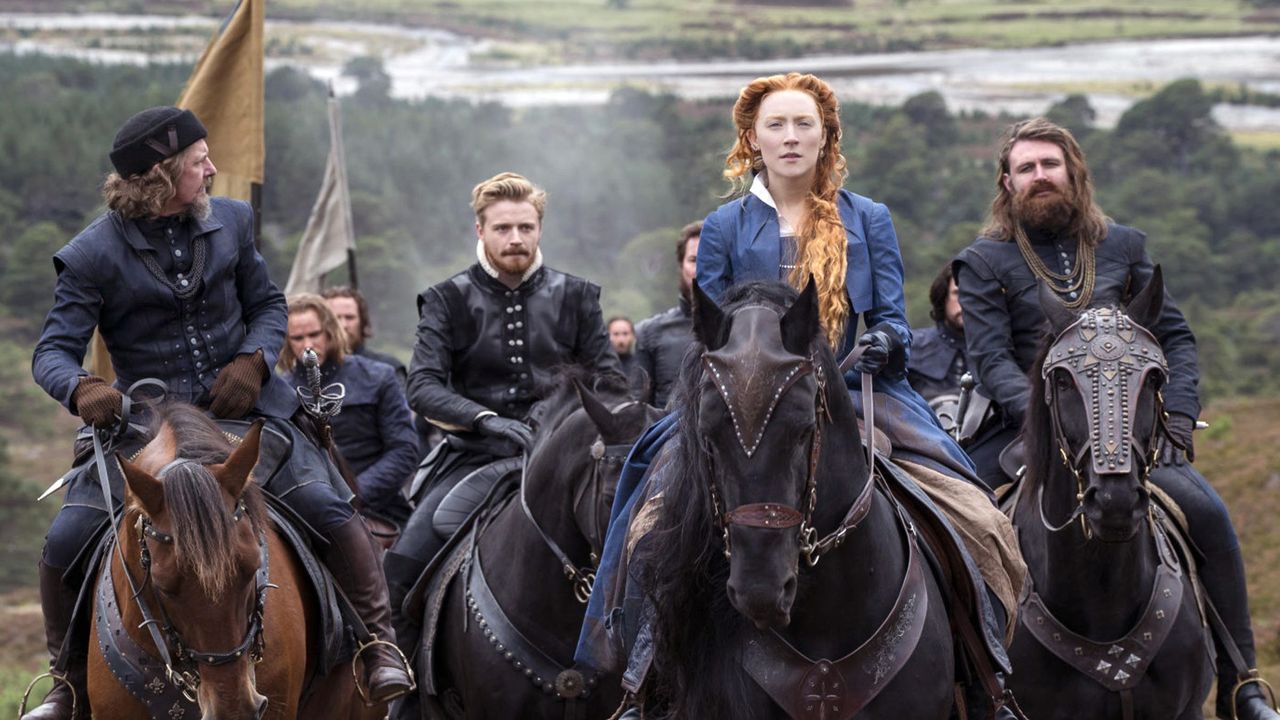 Film still from Mary Queen of Scots (2018) showing characters on horseback in the countryside