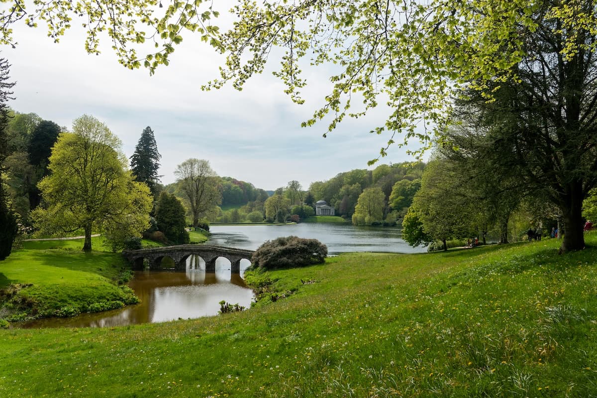 Stourhead landscape gardens with stone bridge over lake and Pantheon temple, a Pride and Prejudice filming location in Wiltshire