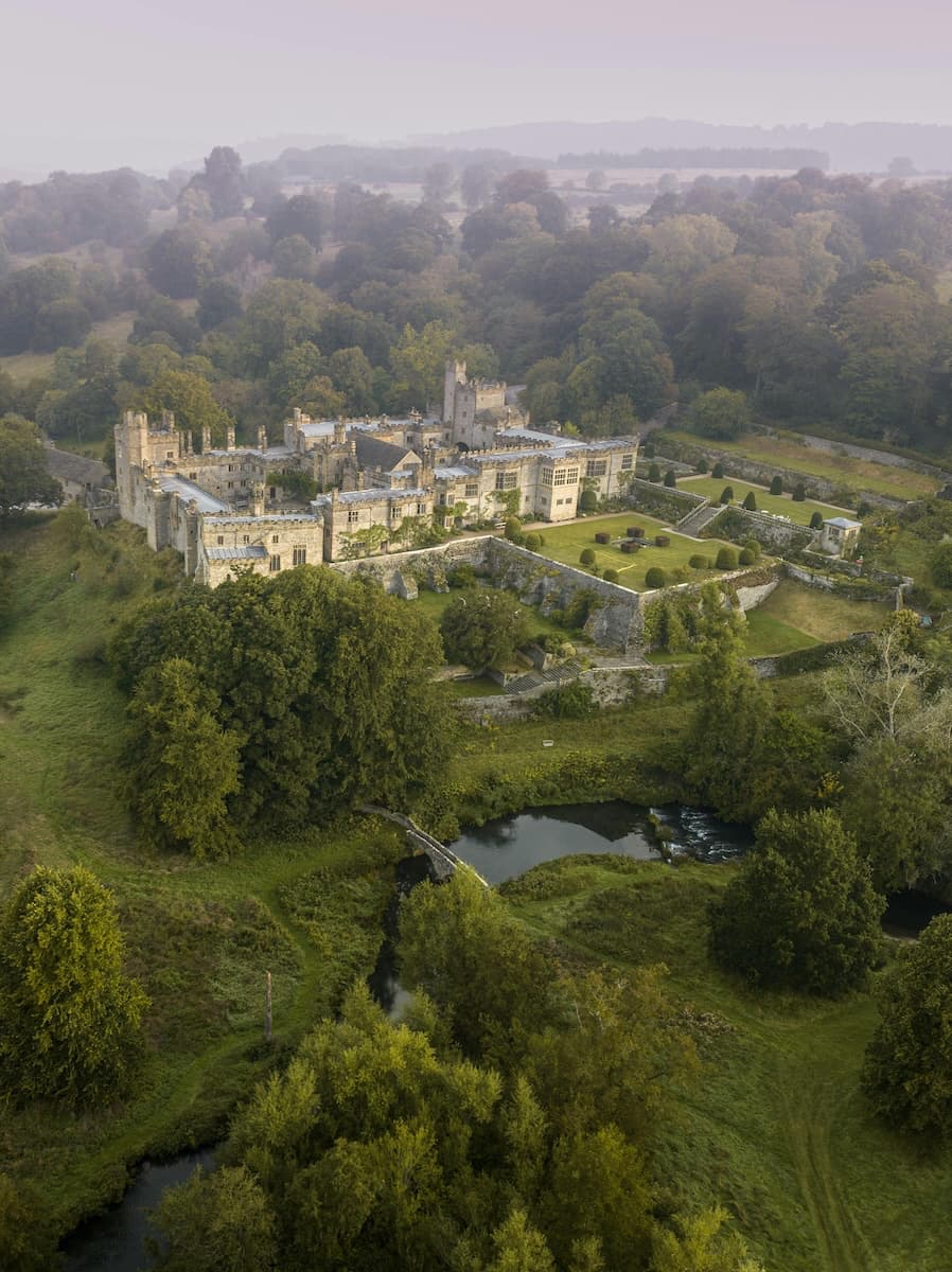 Aerial view of Haddon Hall medieval castle amid green Derbyshire countryside, filmed as Pemberley in Pride and Prejudice (2005)