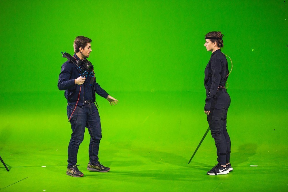 image of two actors filming a scene against a green screen